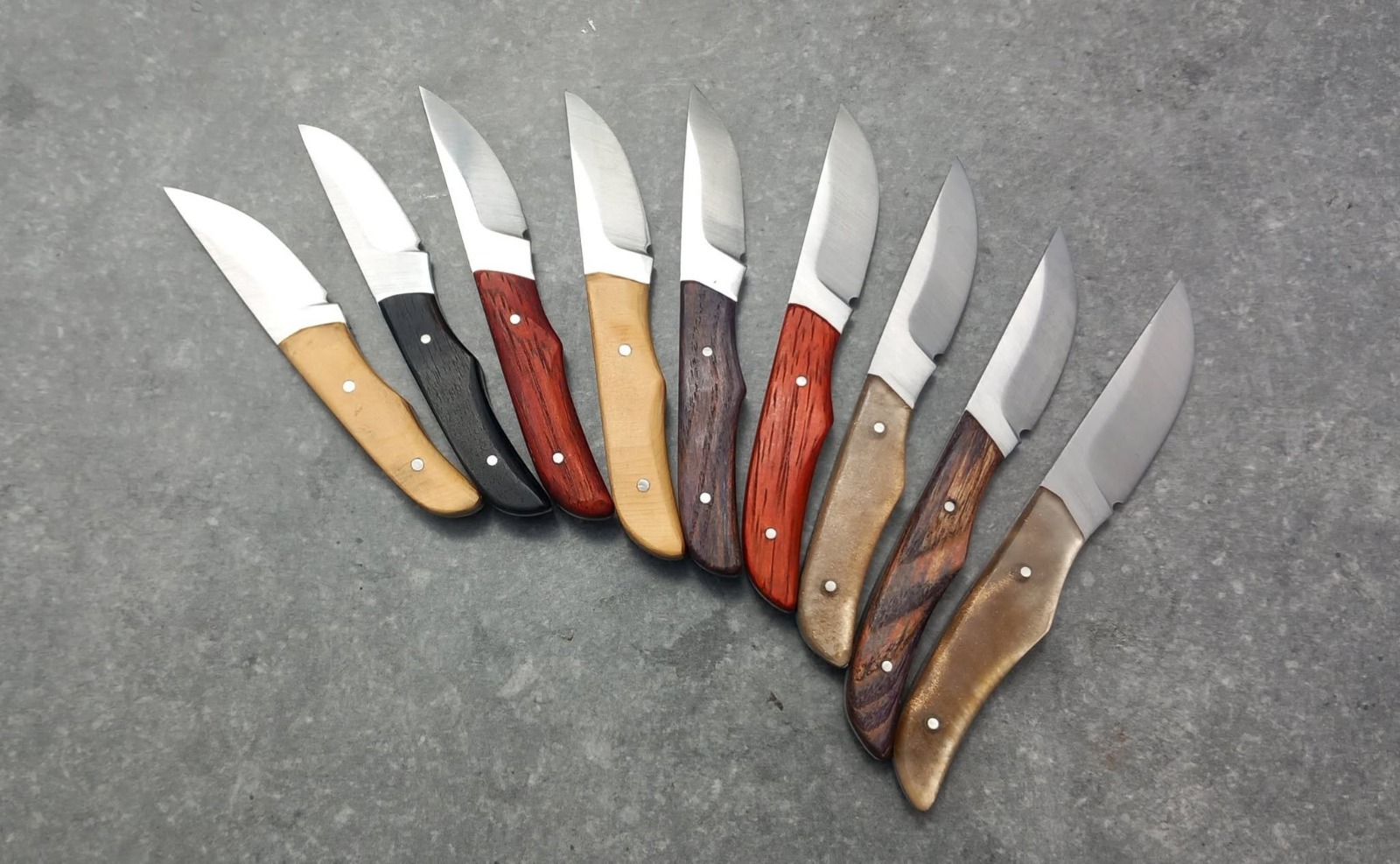 Dix couteaux de poche forgés à la main, manches en bois précieux variés