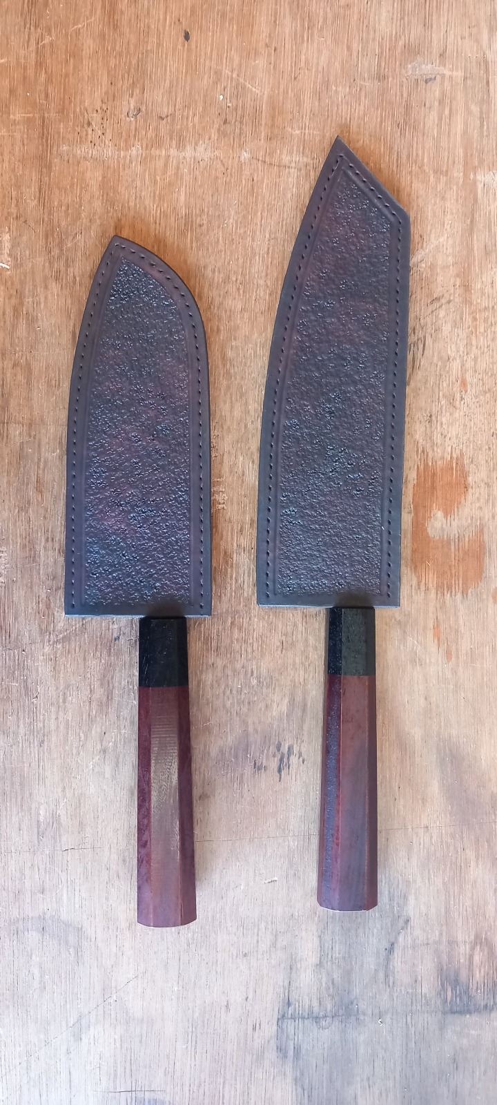 Deux couteaux de cuisine dans leurs étuis en cuir noir cousus main