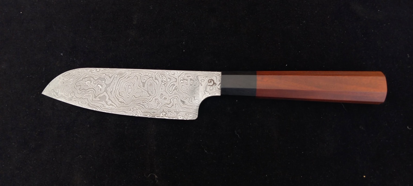 Santoku damas sur fond noir, manche en bois de rose et virole en ébène