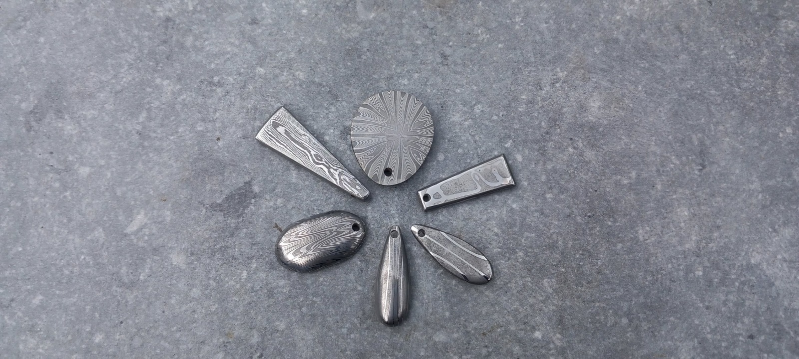 Pendentifs en acier damas et mokume aux motifs concentriques