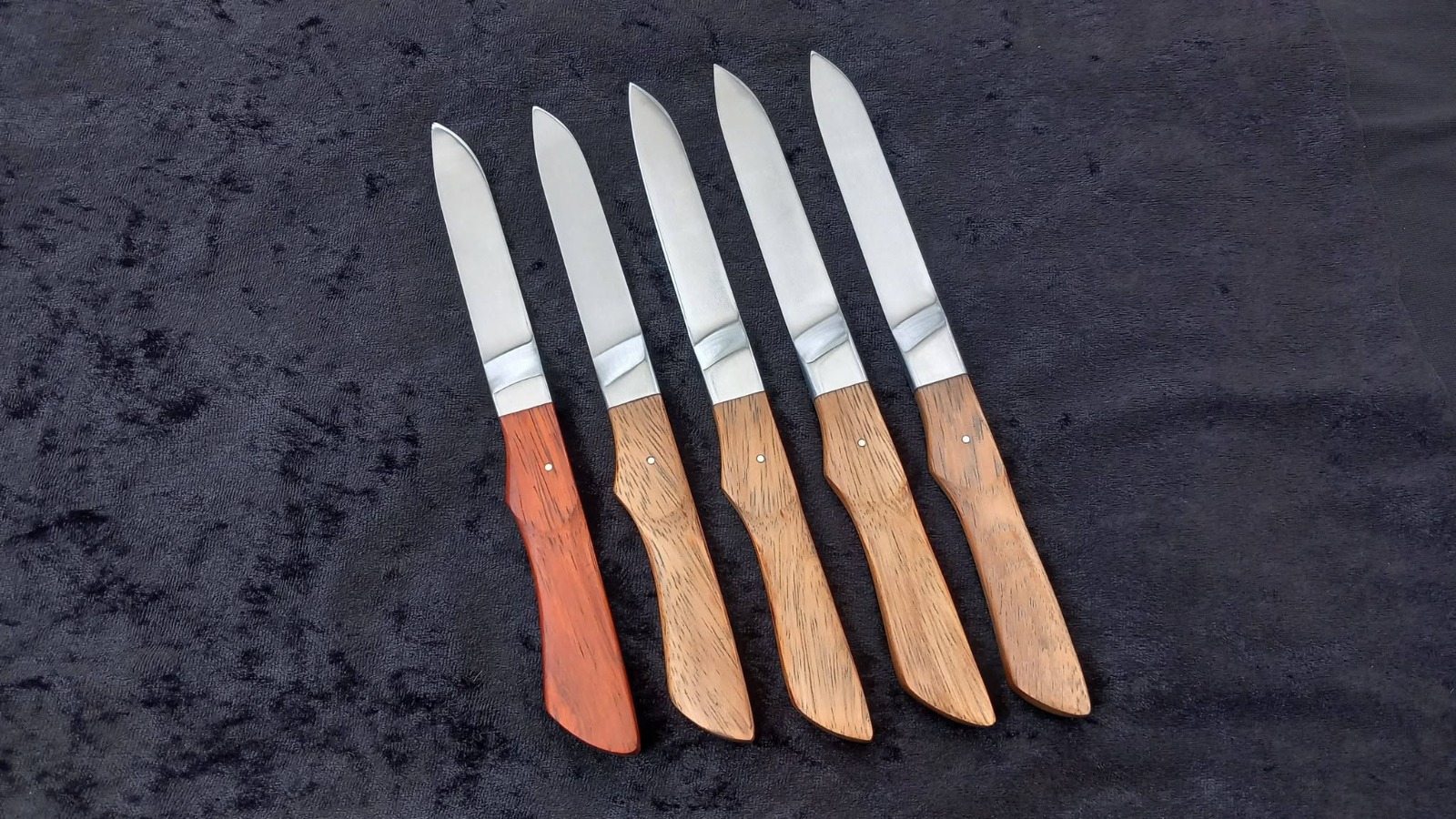 Série de cinq couteaux de table forgés à la main, manches en bois sculptés