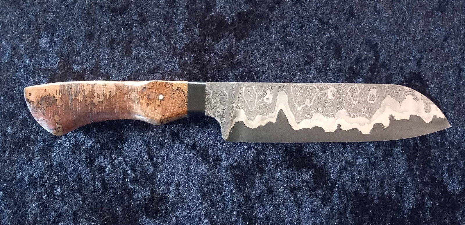 Ligne de damas ondulée sur une lame de cuisine forgée à l'atelier