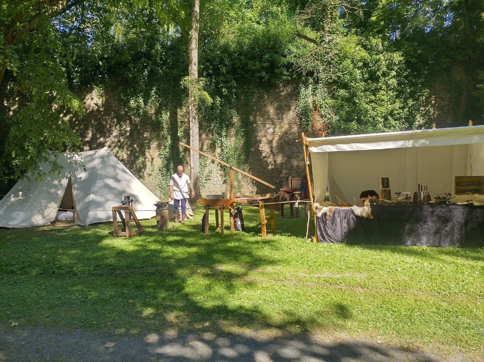 Campement de La Forge d'Aréga avec tente, forge et table de présentation des créations